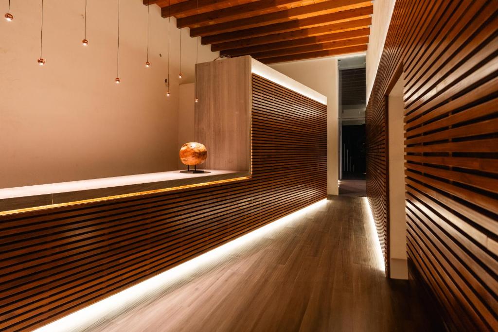 een gang met een houten wand en een vaas op een tafel bij Hotel Agua de Plata in San Luis Potosí