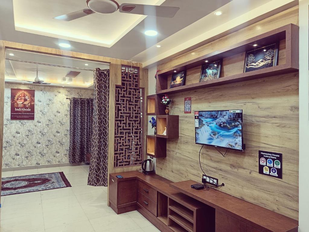 ein Wohnzimmer mit einem TV an einer Holzwand in der Unterkunft Geeta's Luxuria in Varanasi