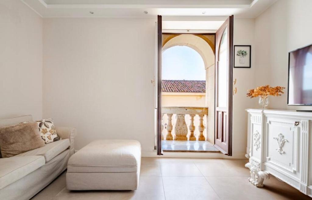 ein Wohnzimmer mit einem Sofa und einer offenen Tür in der Unterkunft Spàzio apartments Sangiuliano in Catania