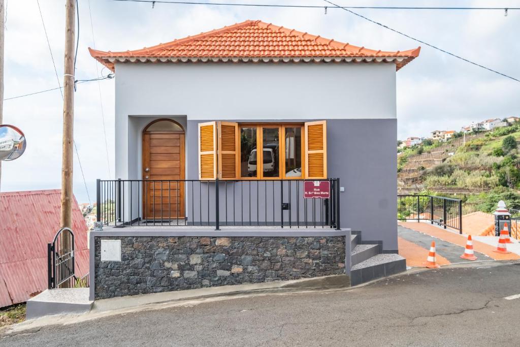 a small white house with an orange roof at Casa da Feira - Located in a peaceful Calheta area with sea views in Calheta