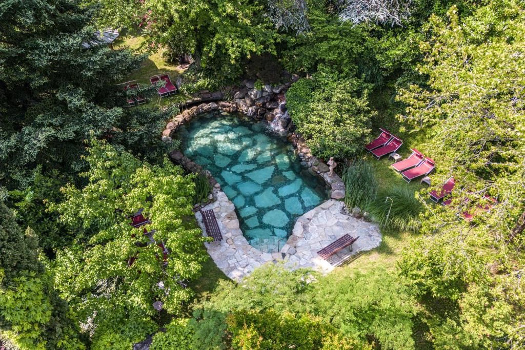 an overhead view of a swimming pool with chairs and trees at Hotel Braunsbergerhof in Lana