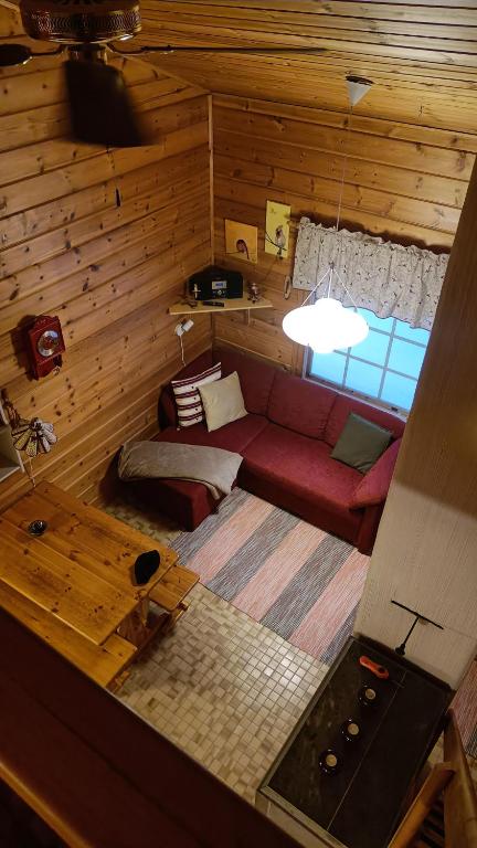 a living room with a red couch and a window at Ylläs Nilikammi in Ylläsjärvi