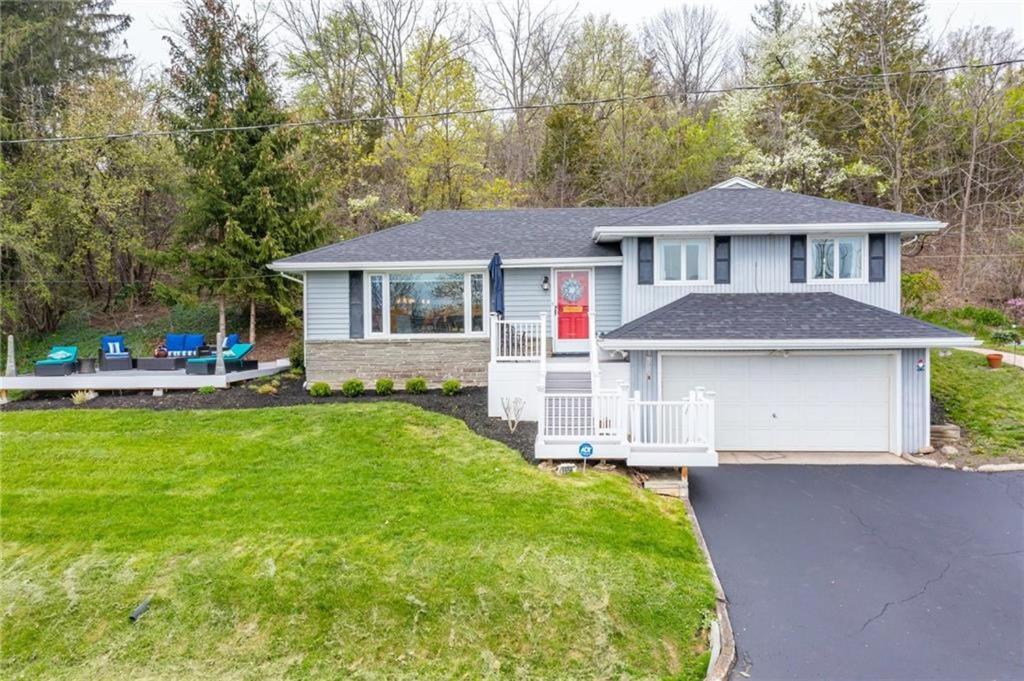 una casa bianca con una porta rossa e un cortile di Canandaigua Lake Overlook a Canandaigua