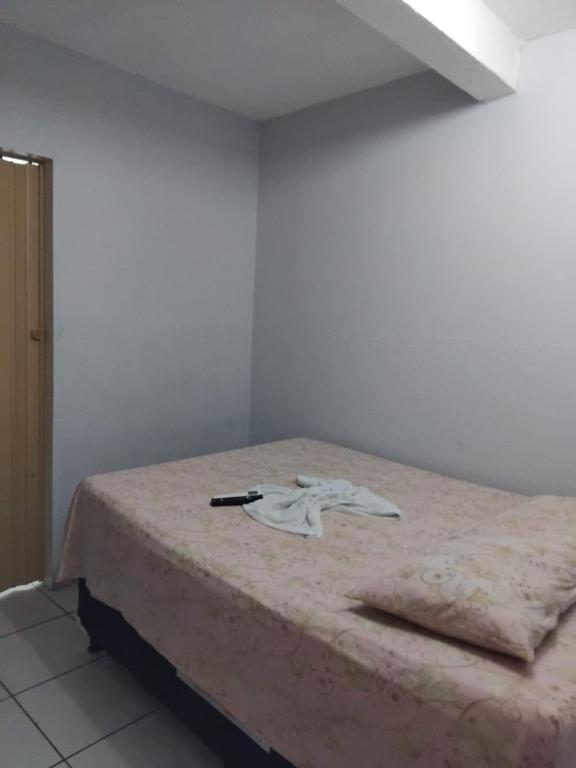 a bedroom with a bed with a pen on it at Pousada praia avenida in Maceió