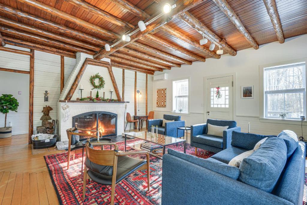 a living room with blue couches and a fireplace at Charming Jaffrey Cottage with Deck and Grill! in Jaffrey