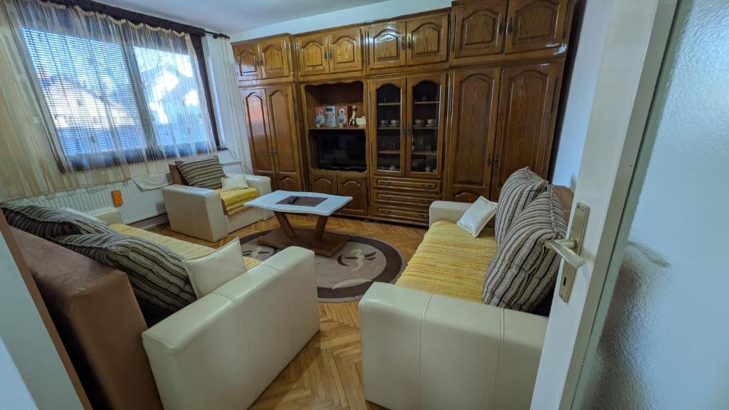 een woonkamer met twee banken en een tafel bij apartman Stojković in Petrovac na Mlavi