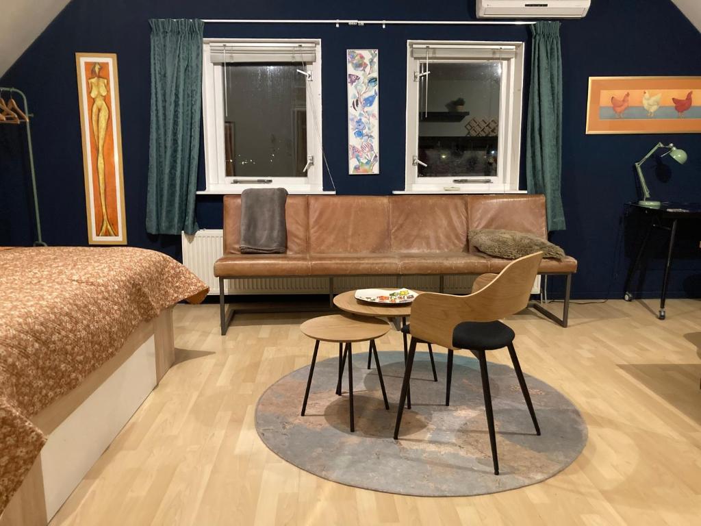 een slaapkamer met een bed, een bank en een tafel bij Appartementen Elzentuin in Oud-Beijerland