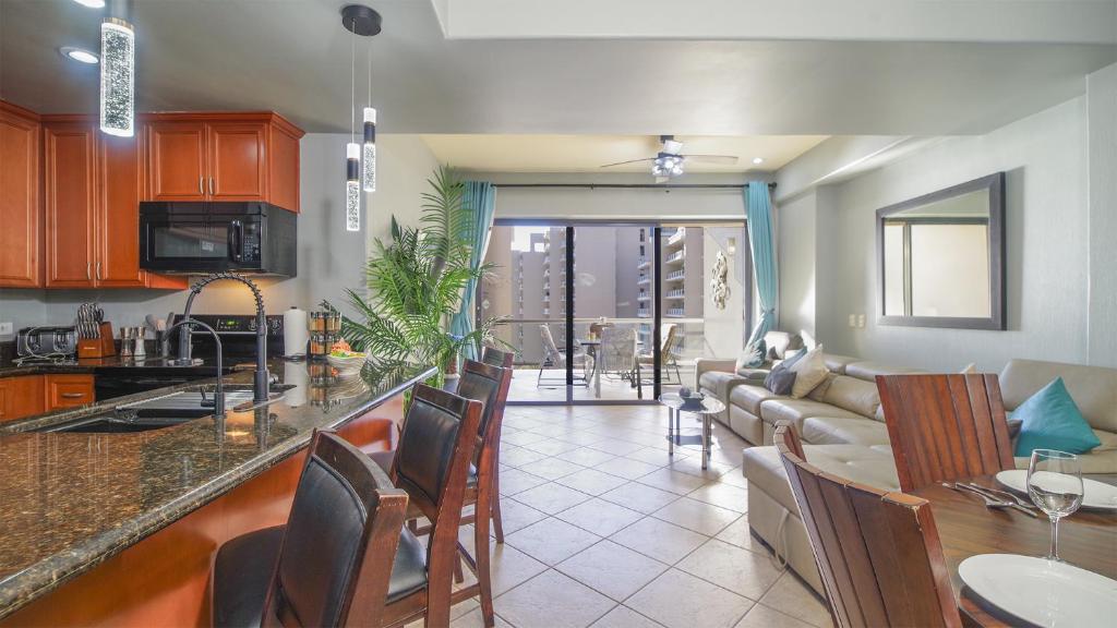 a kitchen and living room with a couch and a table at Las Palomas Beach & Golf Resort in Puerto Peñasco