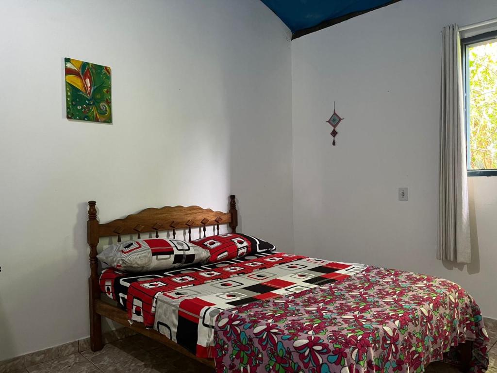 a bedroom with a bed with a quilt on it at CANTINHO do SILENCIO in Morro de São Paulo