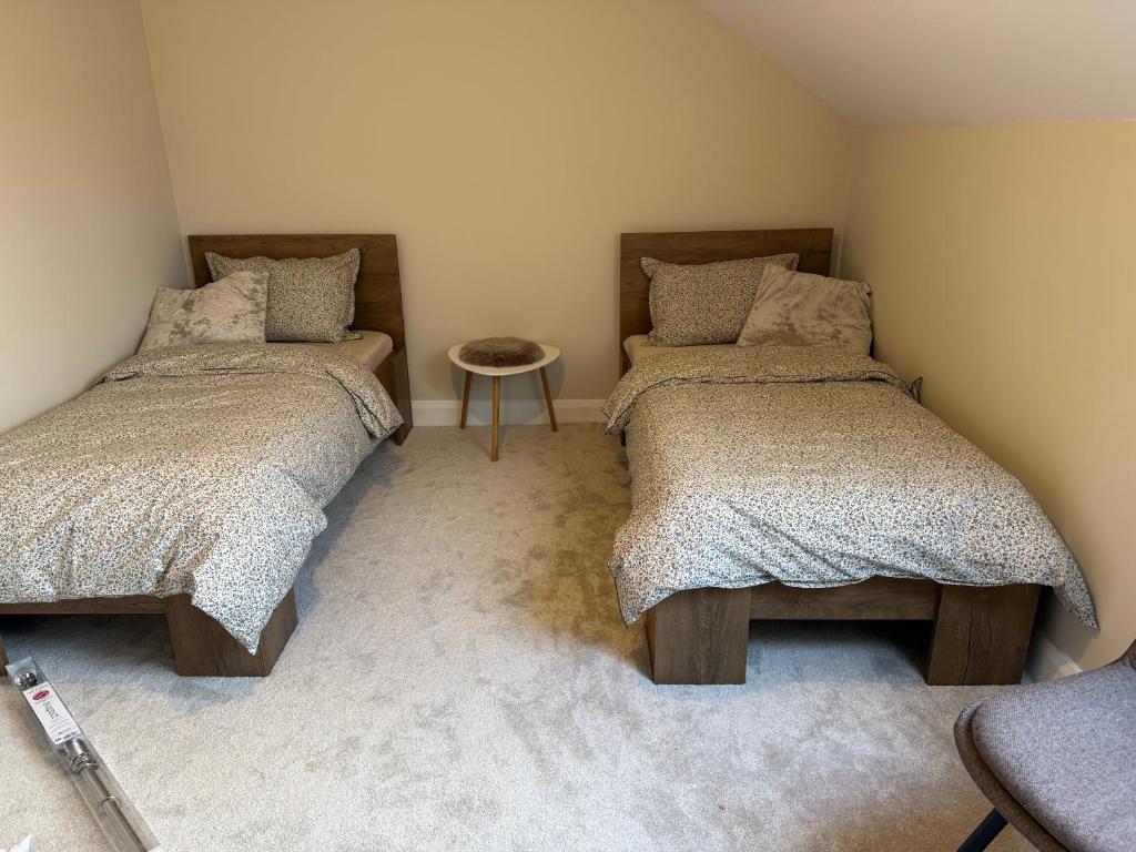 een slaapkamer met 2 bedden en een tafel bij Guests house in Sligo