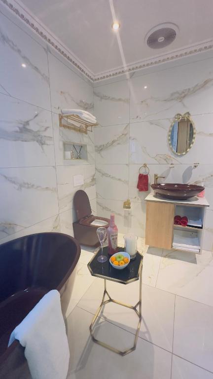 een woonkamer met een tafel en een stoel bij Princess & Alfreds Palace in Gqeberha