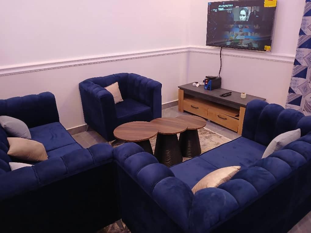 a living room with a blue couch and a table at Villa MBOLO in Pointe-Noire