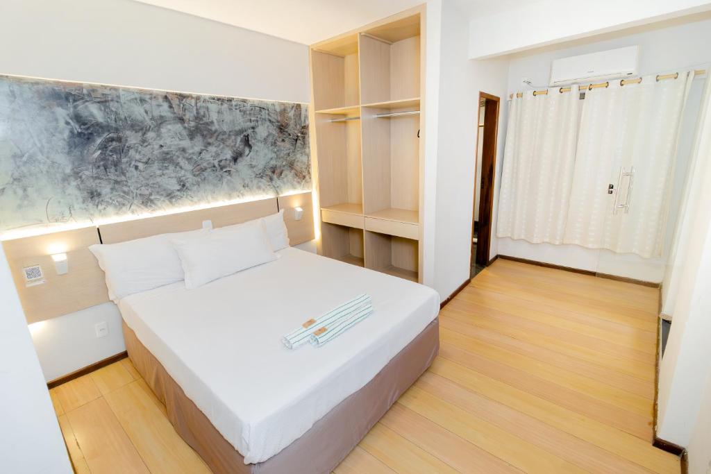 a bedroom with a white bed in a room at Hotel & Restaurante Paraíso Ponte Nova - Ponte Nova - MG in Ponte Nova