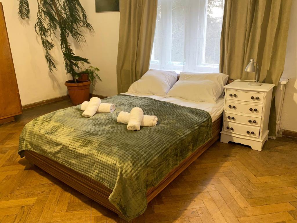 a bedroom with a bed with two towels on it at Uzdrowiskowe Retro by LibertaRent in Szczawno-Zdrój