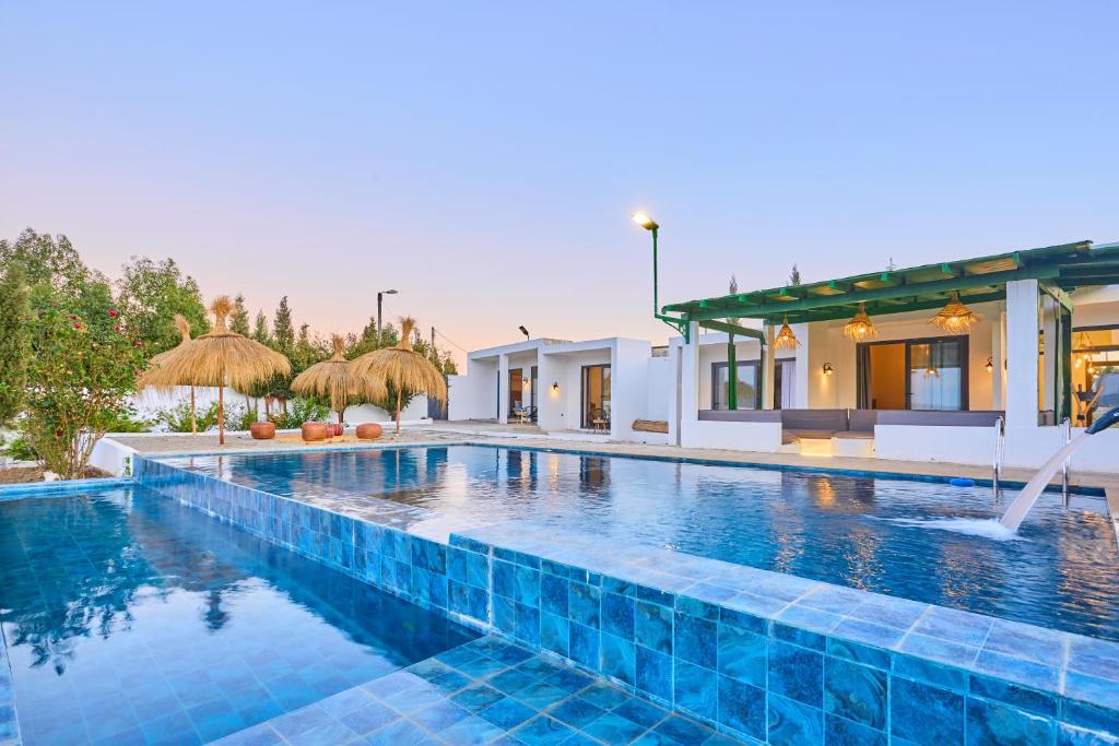 een groot zwembad met blauwe tegels voor een huis bij Dar Charkaoui in Tetouan