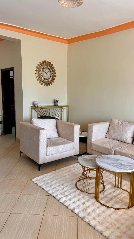 a living room with two couches and a table at Pure Haven in Mbale