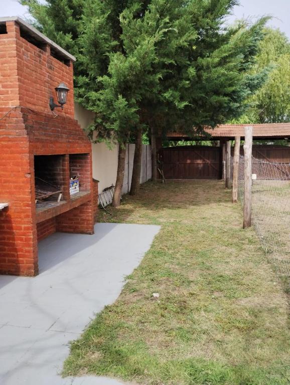 a brick building next to a yard with trees at Depto TOMY in Mar de Ajó