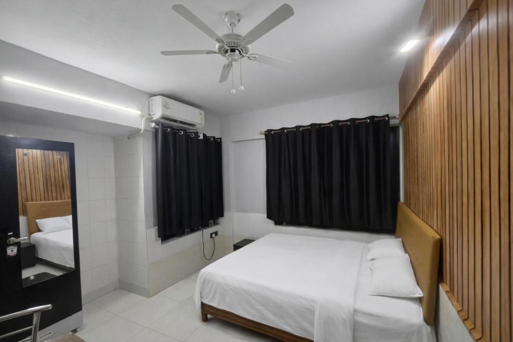 a bedroom with a bed and a ceiling fan at Family Home 2BHK Apartment Thane West in Thane