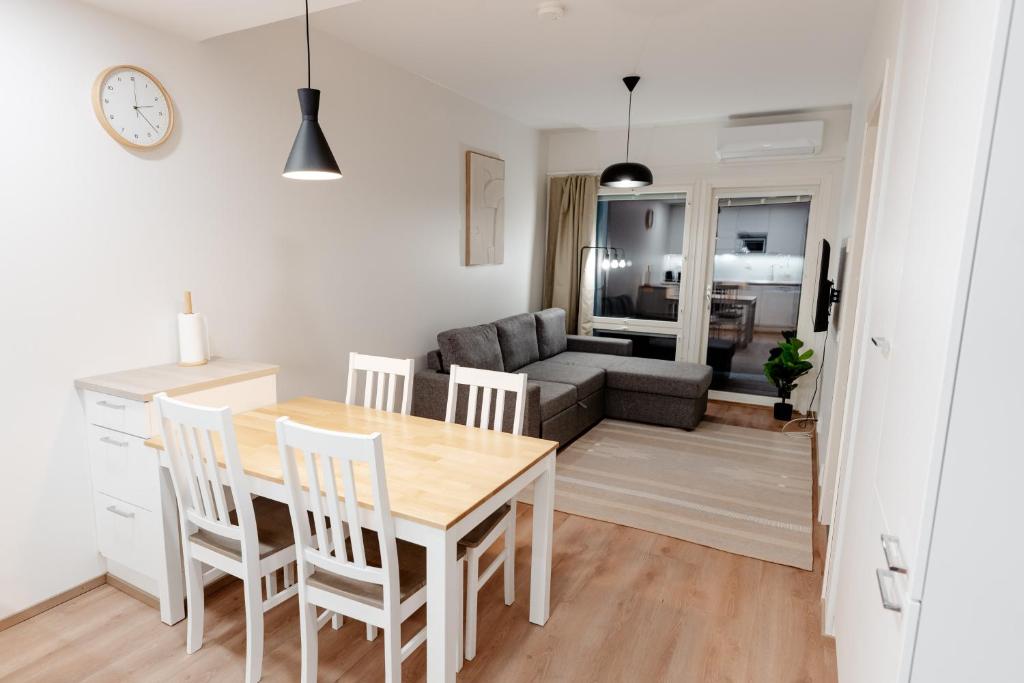 a kitchen and living room with a table and chairs at Snowflake Suites VIII with private sauna in Rovaniemi