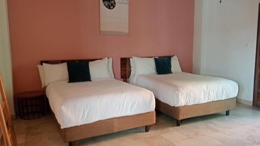 twee bedden naast elkaar in een kamer bij Hotel Kupuri in Sayulita