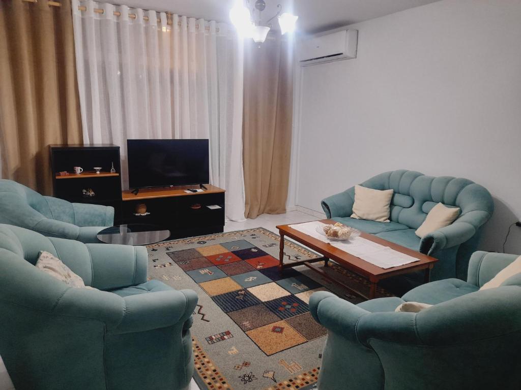a living room with two blue chairs and a coffee table at Tirana center view in Tirana