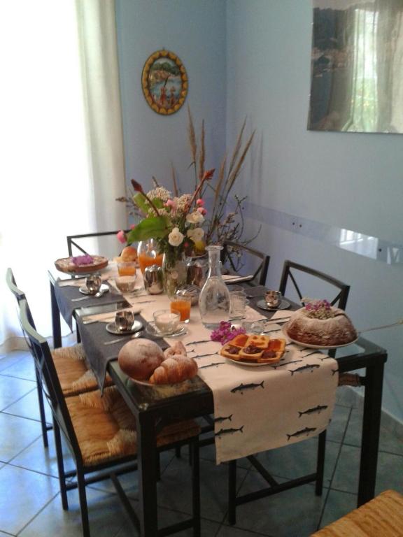 una mesa de comedor con comida y flores. en La Sorgente B&amp;B, en Cetara