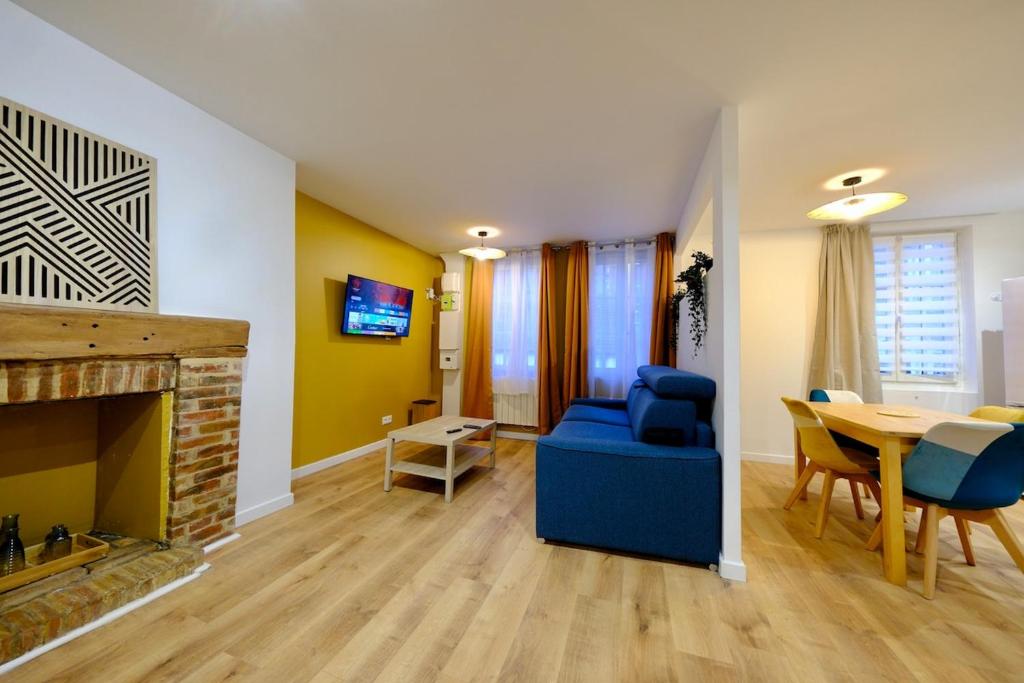 ein Wohnzimmer mit einer blauen Couch und einem Kamin in der Unterkunft Elbeuf - Appartement moderne pour 4 in Elbeuf