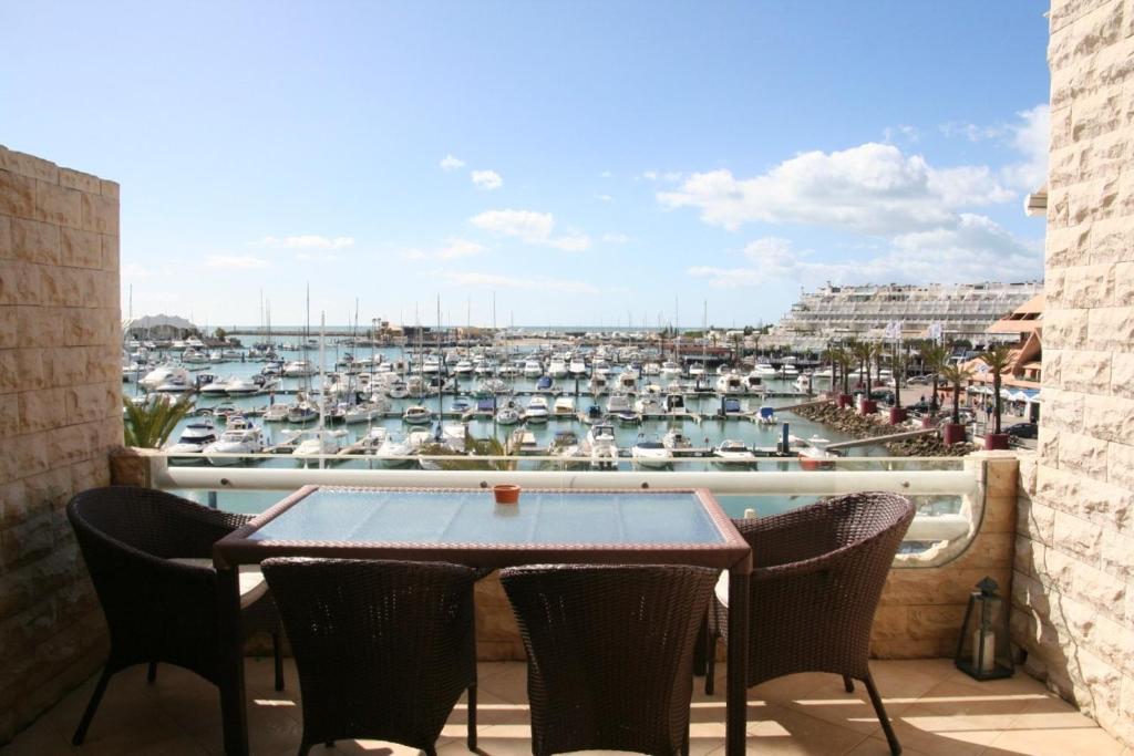 a balcony with a table and chairs and a marina at Triplex Marina Vilamoura in Vilamoura