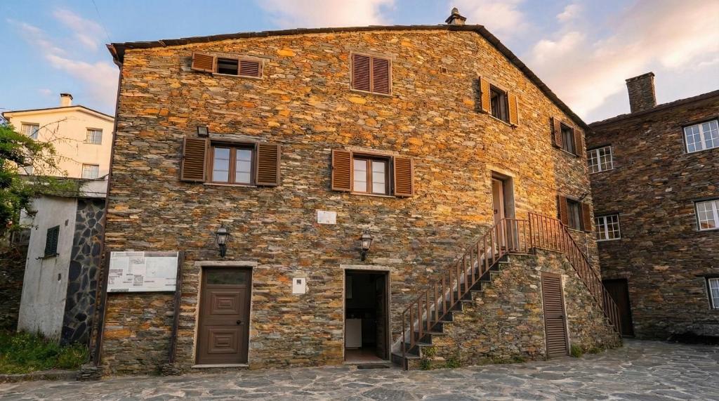 an old brick building with a staircase in front of it at Égua Nature House in Piódão