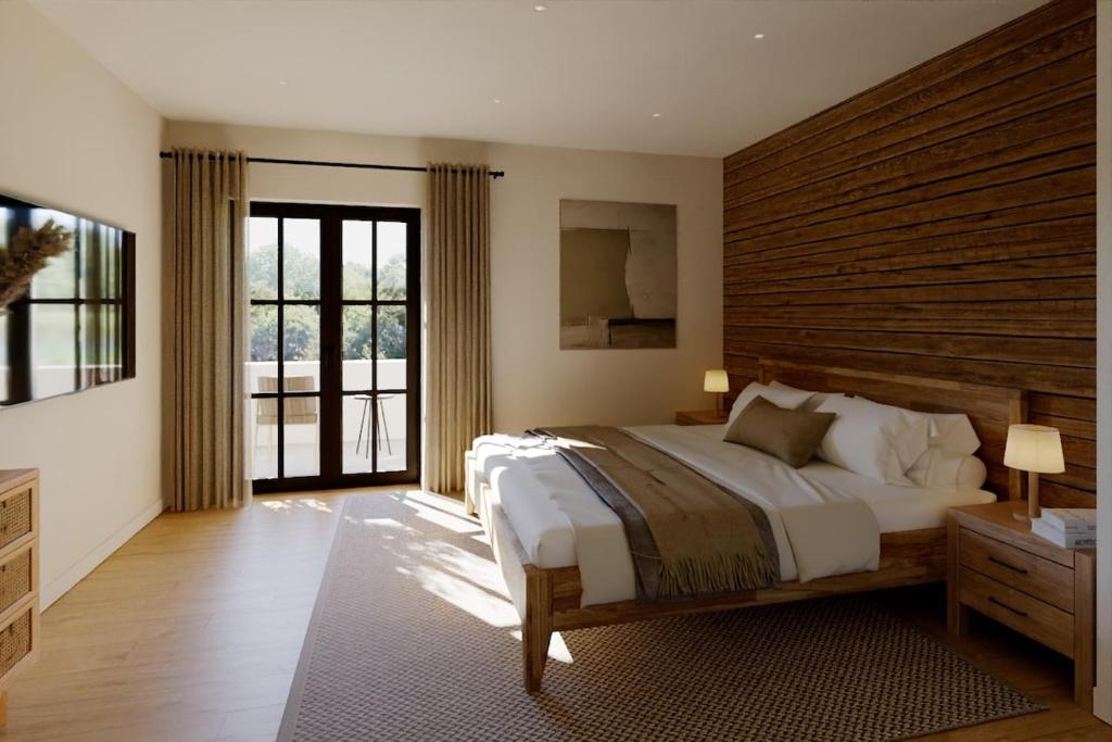 une chambre avec un grand lit et une grande fenêtre dans l'établissement Ferienwohnung Jehl am Tegernsee, à Bad Wiessee