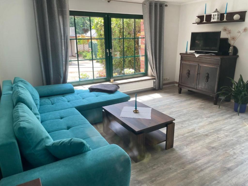 a living room with a blue couch and a table at Apartment am Wurlsee by Interhome in Lychen
