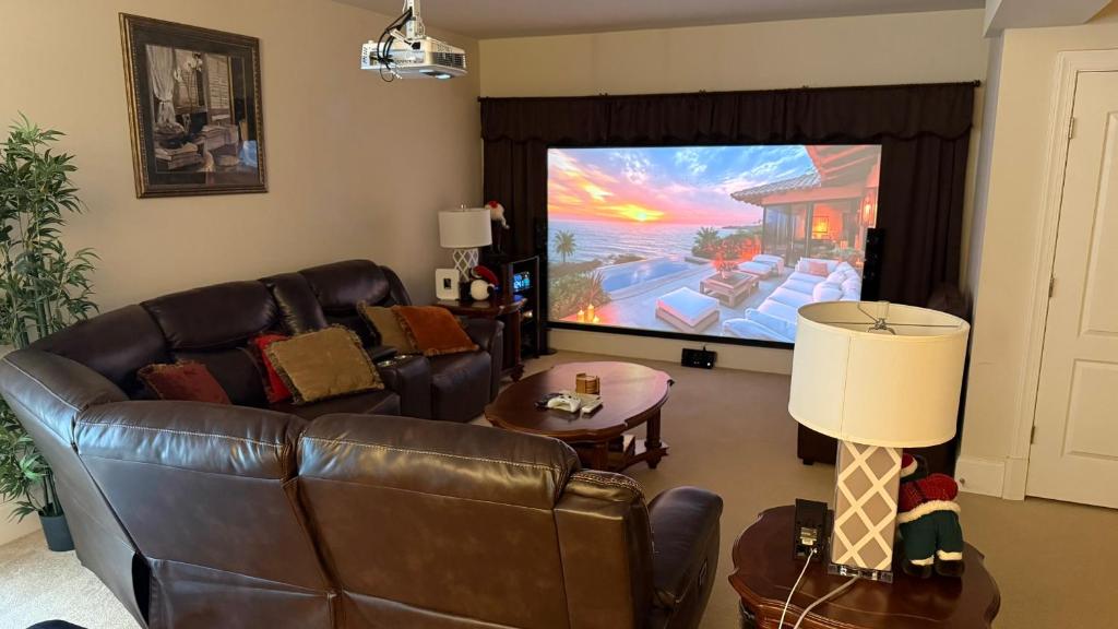 ein Wohnzimmer mit Ledersofa und großem Flachbildfernseher in der Unterkunft Luxurious spacious apartment with private entrance in Clifton