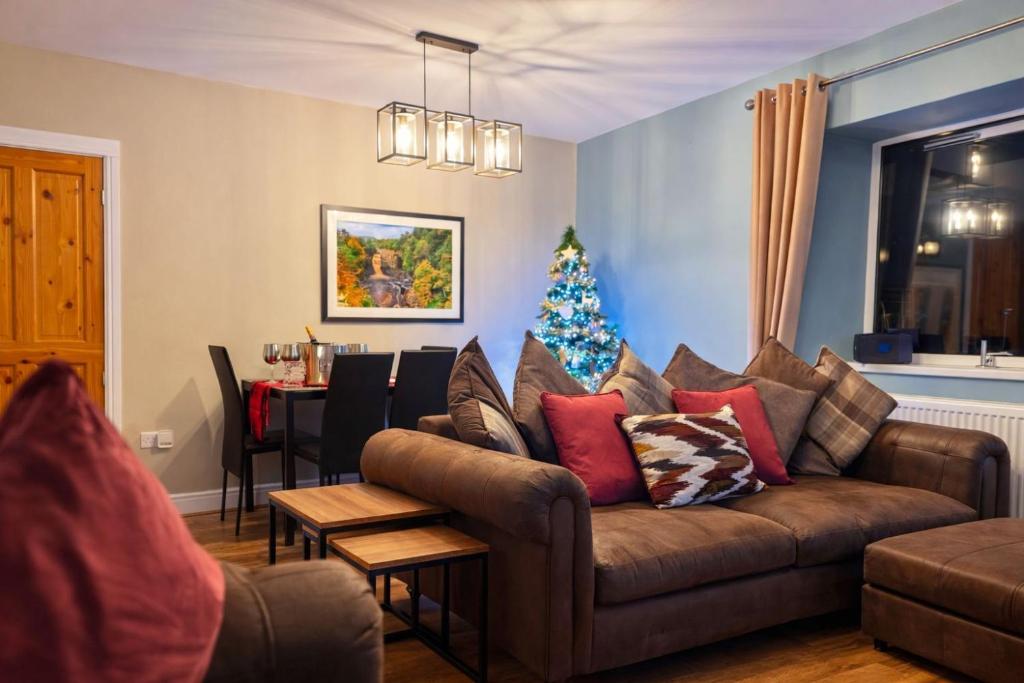 een woonkamer met een bank en een kerstboom bij The Hideaway in Durham