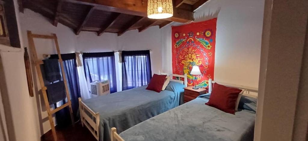 a bedroom with two beds and a painting on the wall at Grace’s House, Ezeiza Airport in Monte Grande