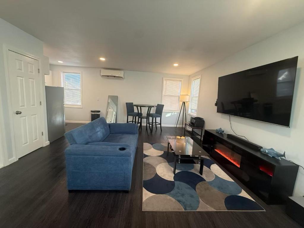 a living room with a blue couch and a flat screen tv at Lucy Private Studio in Providence