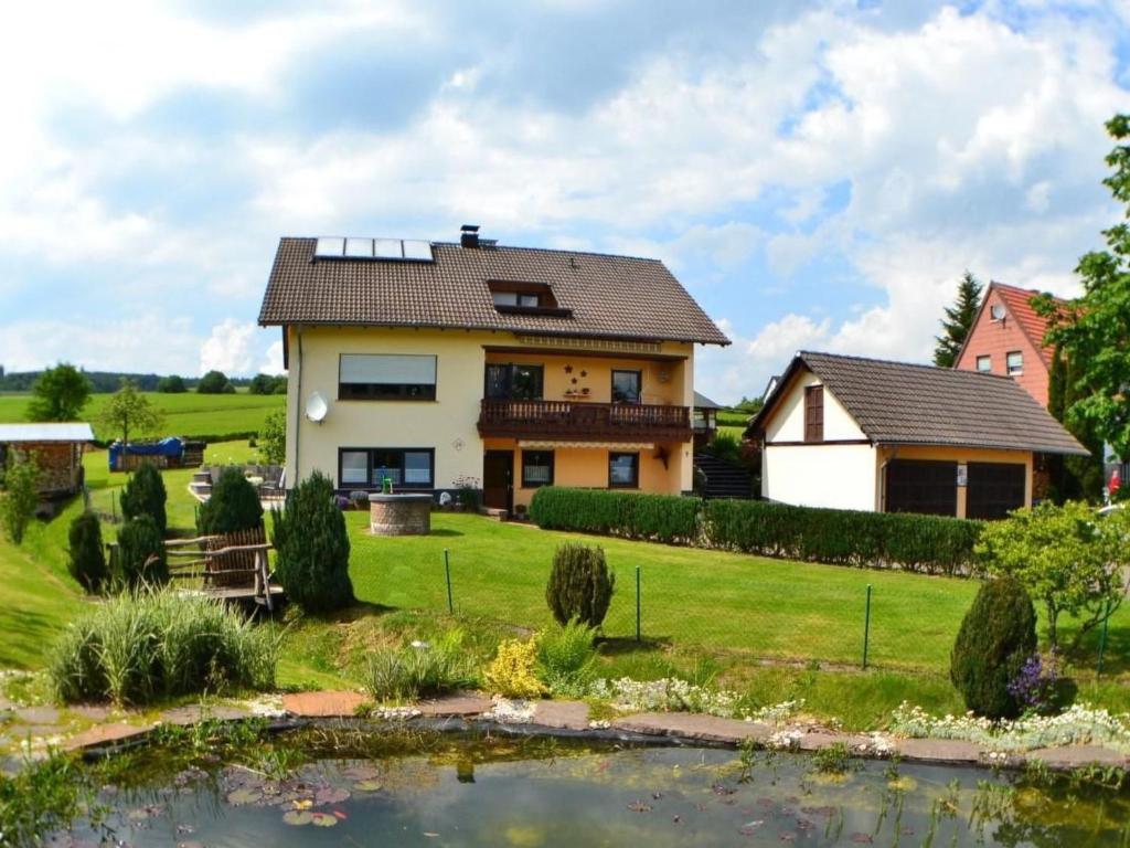 a house with a pond in front of it at Apartment Haus-Trapp by Interhome in Unterbernhards