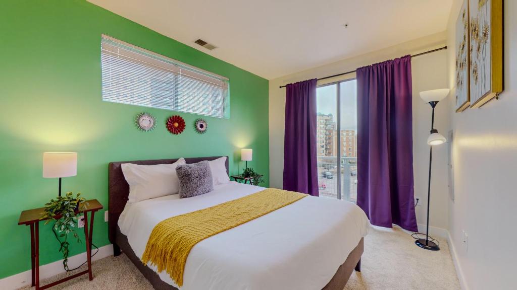 um quarto com uma cama e uma janela com cortinas roxas em Stamford Cozy Apartment with free parking em Stamford