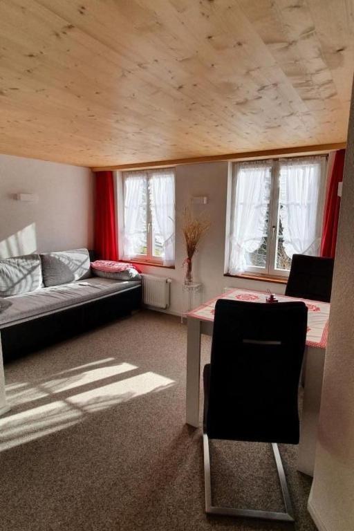a living room with a couch and a table with a chair at Apartment GLORIOS by Interhome in Heiden