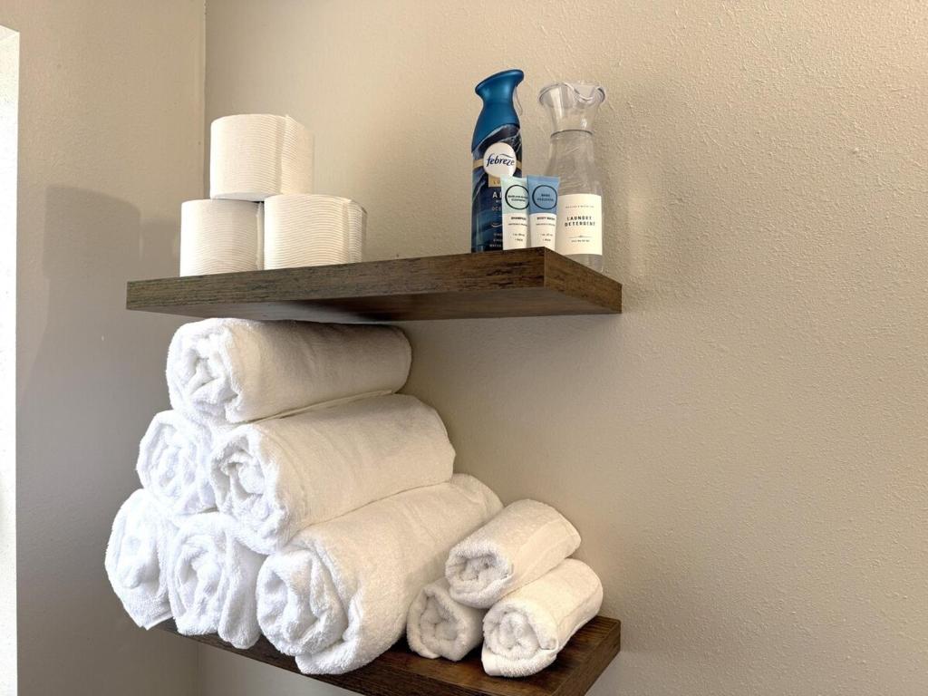 een stapel handdoeken en toiletpapier op een plank bij River Side Private Retreat in Seguin