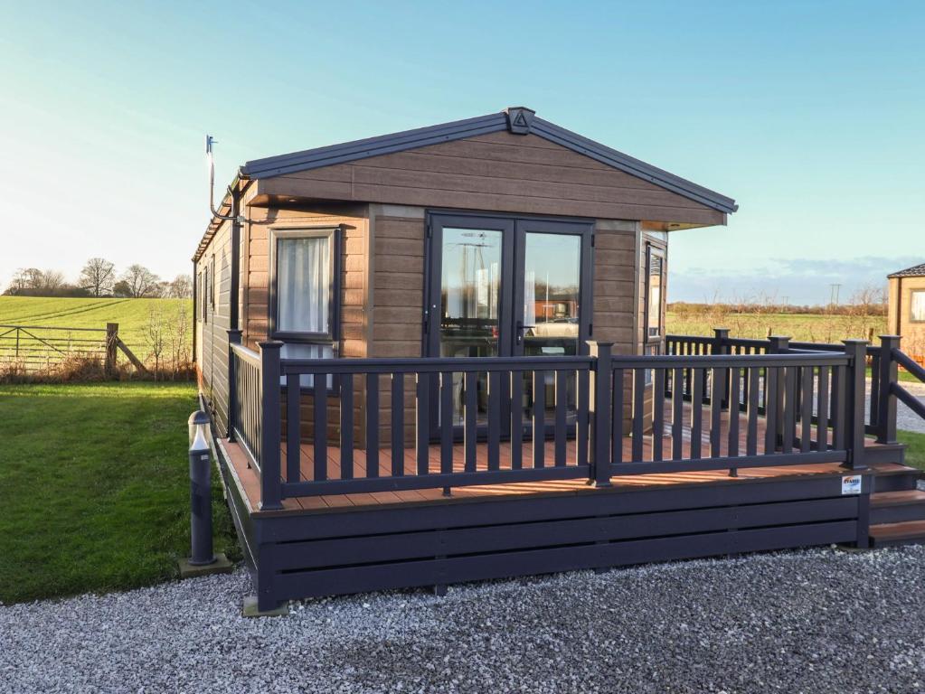 een klein huisje met een groot terras bij Meadows Park 4 in Hull