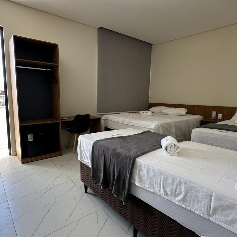 a hotel room with two beds and a television at Hotel do Vale in Petrolina