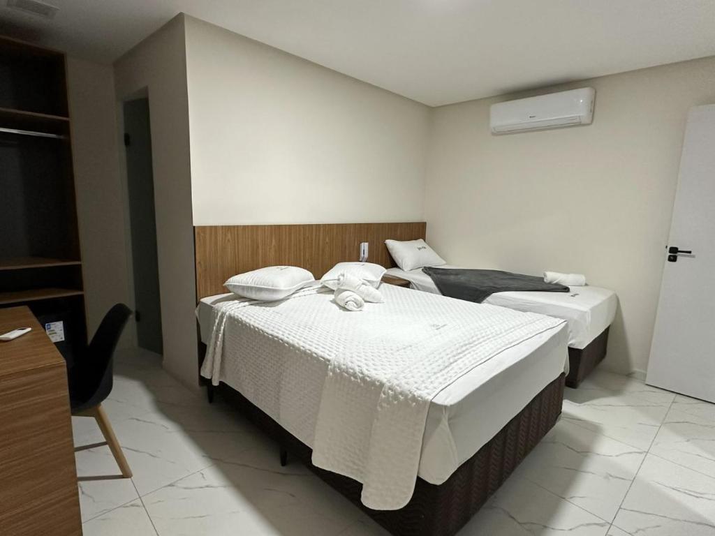una camera d'albergo con due letti con lenzuola bianche di Hotel do Vale a Petrolina