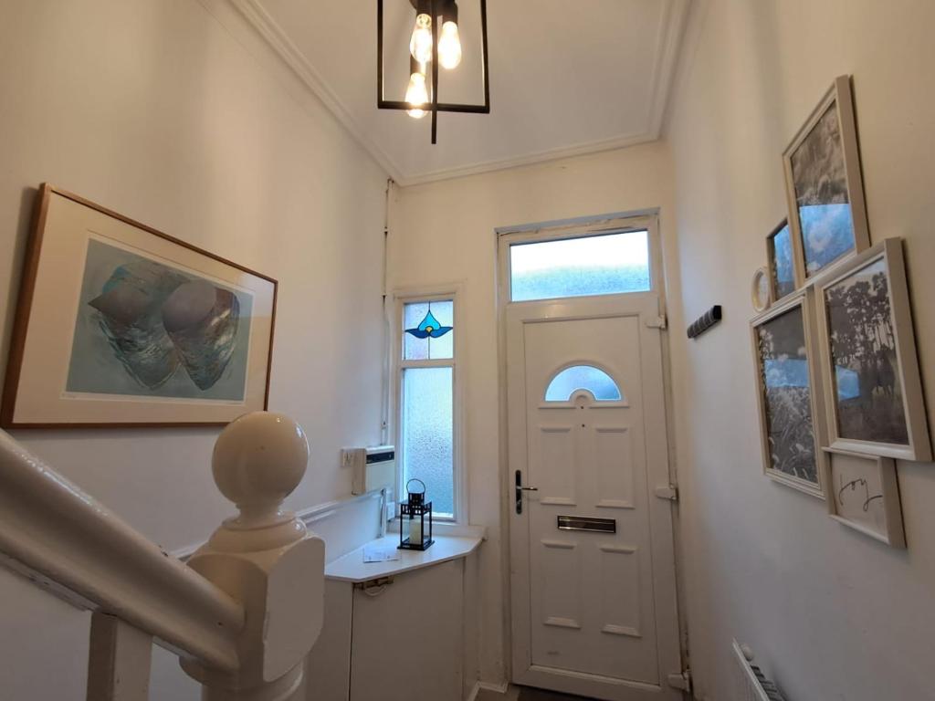 a hallway with a white door and a window at 16 Skipton Road in Liverpool