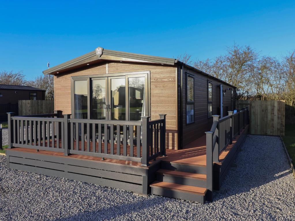 een tiny house met een veranda en een terras bij Meadows Park 2 in Hull