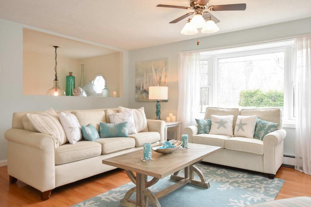 a living room with two couches and a table at Minutes to Private Association in Eastham