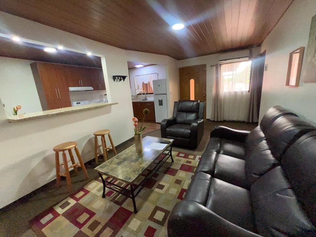 a living room with a couch and a table and chairs at Apartamento completo cerca del Aeropuerto y Parque Viva 5 personas in Guácima