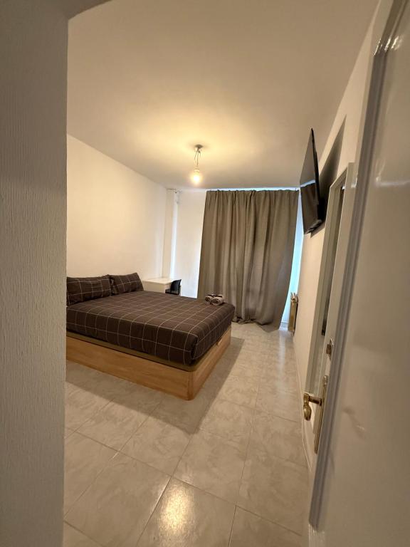 een slaapkamer met een bed en een televisie. bij Onlyroom Madrid Calatrava in Madrid