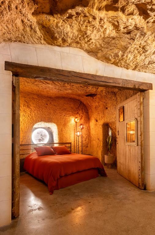 een slaapkamer met een bed in een grot bij Le Cavernacle in Montrichard