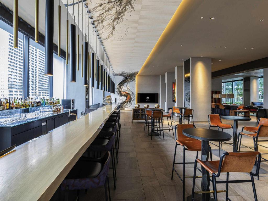 a bar in a restaurant with tables and chairs at Pullman Tokyo Tamachi in Tokyo