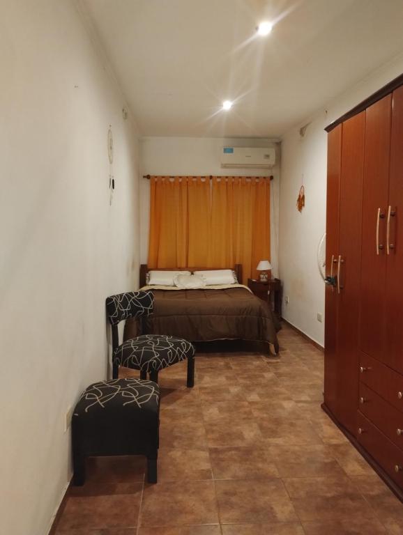 una camera da letto con un letto e due pouf di Departamento céntrico con cochera a Gualeguaychú